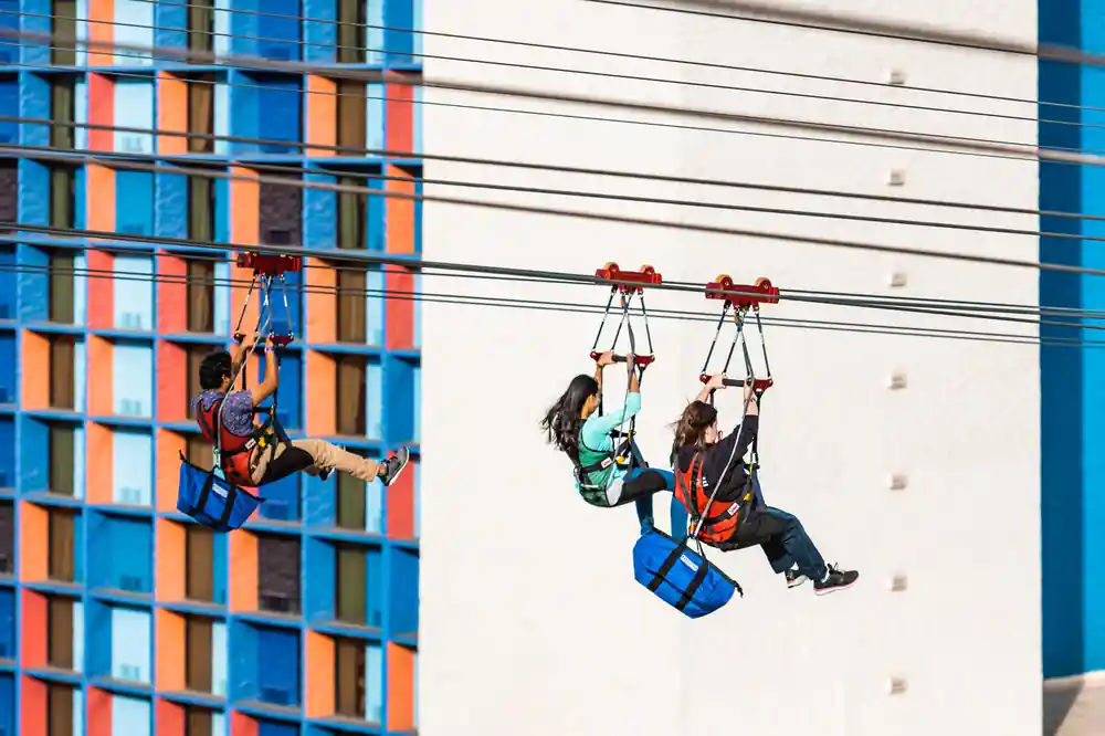 One rider seated and one flying flat, side by side